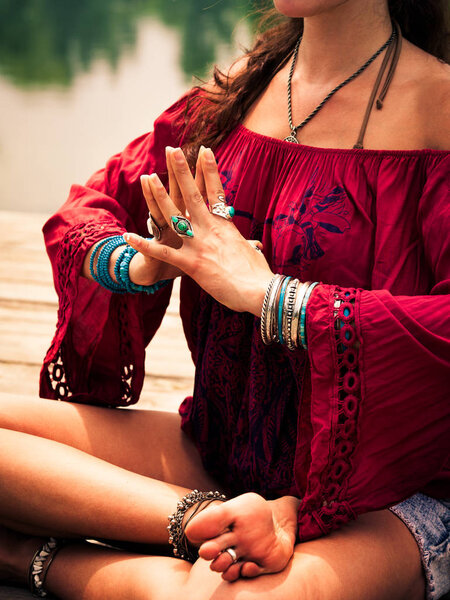 woman in a meditative yoga position by the lake
