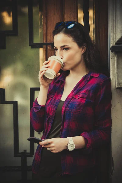 Girl in city with smartphone and takeaway coffee — Stock Photo, Image