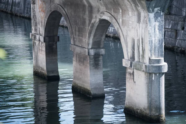 Колонны старого каменного моста через реку — стоковое фото