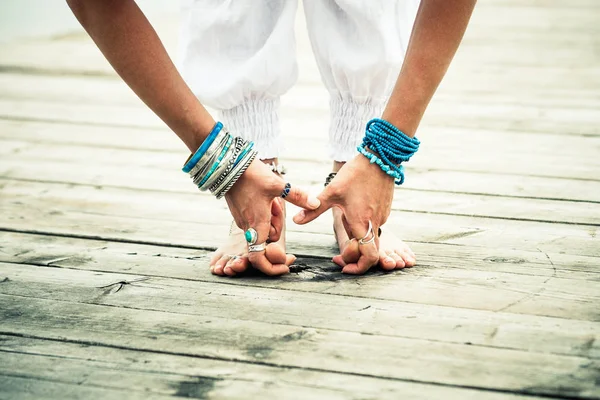 Primo piano di piedi nudi donna piedi e mani pratica yoga all'aperto — Foto Stock