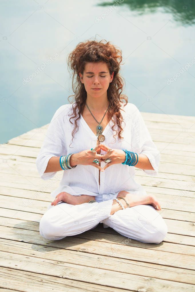 woman practice yoga outdoor by the lake 