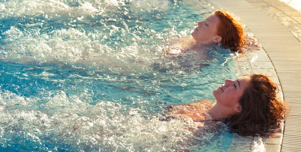 Deux sœurs se détendre dans la piscine style de vie estival — Photo