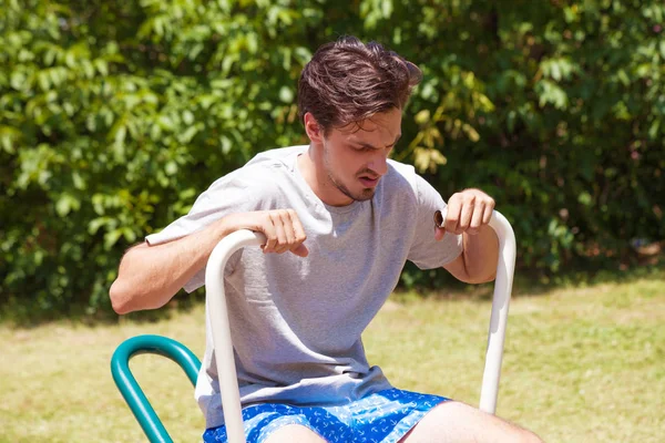 Müder junger Mann nach Übung im Freien auf Rudergerät — Stockfoto
