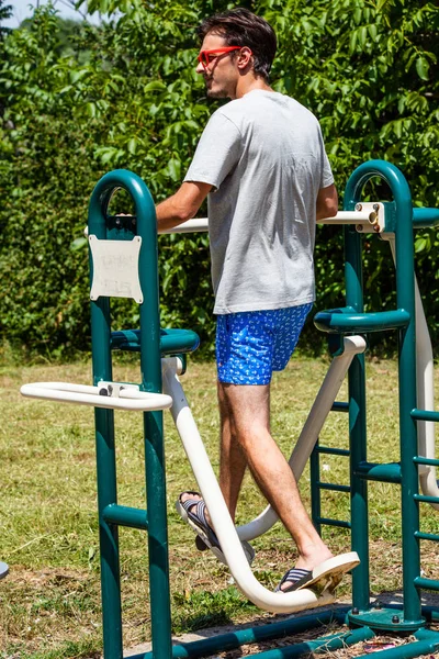 Junger Mann im Freizeitpark auf Stepper — Stockfoto