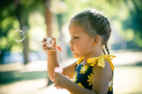 어린 소녀 놀이 공원 타격 비누 거품 프로필에 가까이 — 스톡 사진