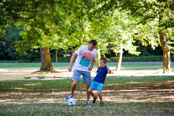 Pai e seu filho jogar futebol no parque — Fotografia de Stock