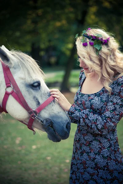 Jonge boho stijl vrouw pat paard in park zomerdag — Stockfoto