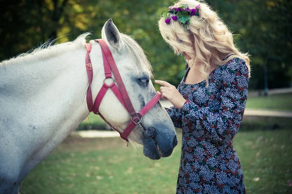 Joven boho estilo mujer palmadita caballo en parque verano día —  Fotos de Stock