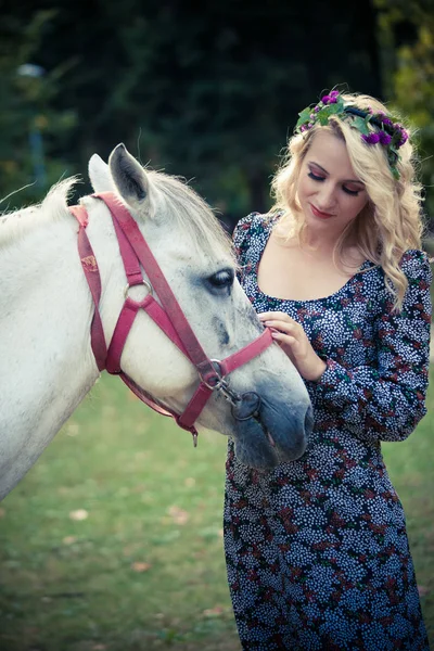Joven boho estilo mujer palmadita caballo en parque verano día —  Fotos de Stock