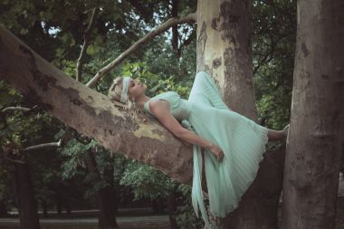 genç ve güzel kadın romantik elbise yalan yaz günü ağaç üzerinde