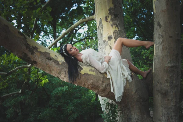 Bella giovane donna capelli scuri in abito romantico a piedi nudi si trovano su — Foto Stock