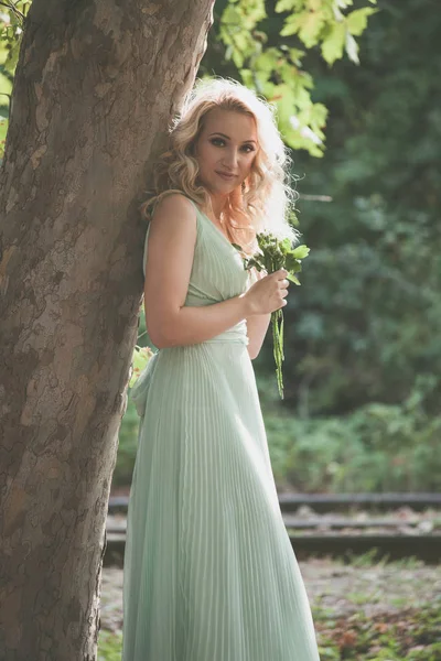 Donna bionda in stile romantico tenere bouquet di fiori selvatici fuori — Foto Stock