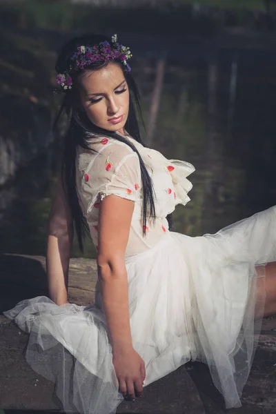 Estilo romántico joven mujer sentarse en pequeño puente de madera sobre el estanque — Foto de Stock