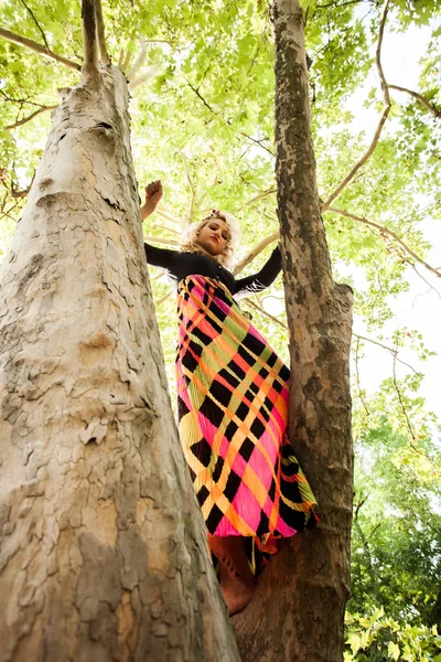 Boho Mädchen in langen bunten Kleid stehen auf Baum im Park Sommer da — Stockfoto