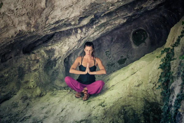 Mujer practica yoga meditación en pequeña cueva — Foto de Stock