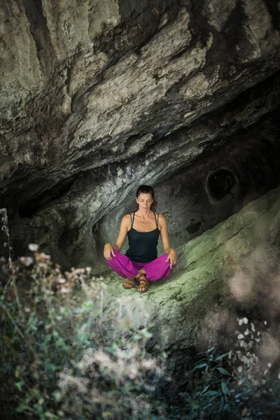 Femme pratique la méditation de yoga dans une petite grotte — Photo