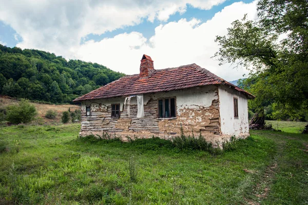 Casa velha abandonada na paisagem montanhosa rural — Fotografia de Stock