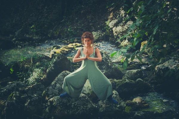 Jeune femme pratique le yoga en plein air dans le lit de la rivière de petite montagne — Photo
