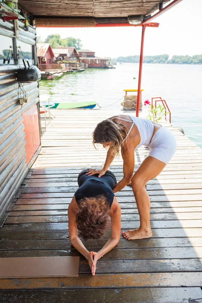 Femme instructeur de conditionnement physique aider la jeune femme dans l'exercice outdo — Photo