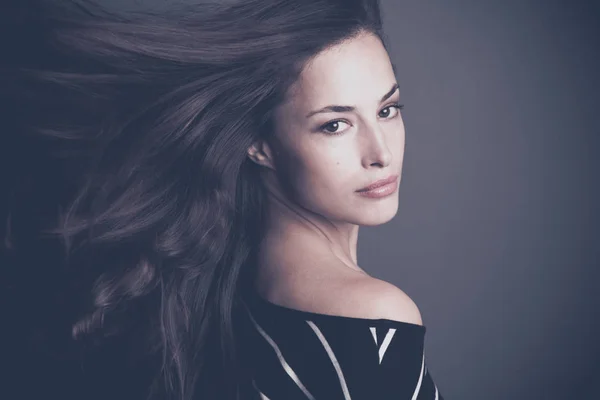 Bela jovem morena mulher com cabelo em estúdio movimento — Fotografia de Stock