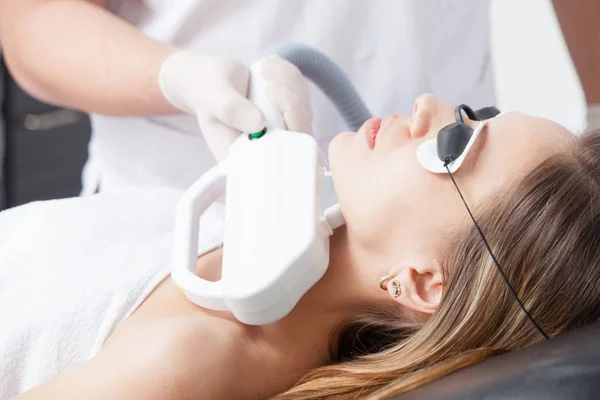 Vrouw tijdens gezicht lasertherapie in cosmetica — Stockfoto