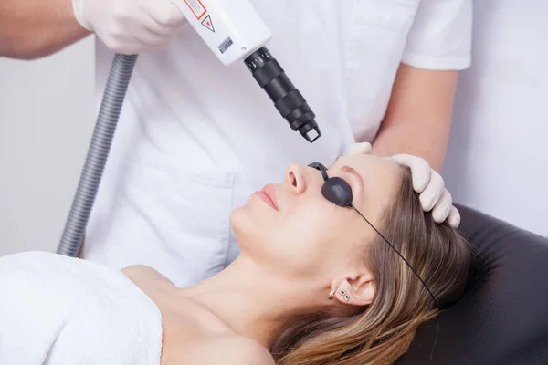 Mujer durante la terapia con láser facial en cosméticos — Foto de Stock