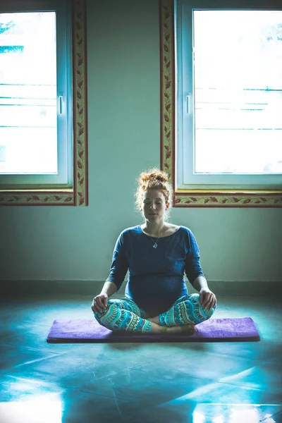 Rött huvud gravid ung kvinna på yogaklass inomhus — Stockfoto