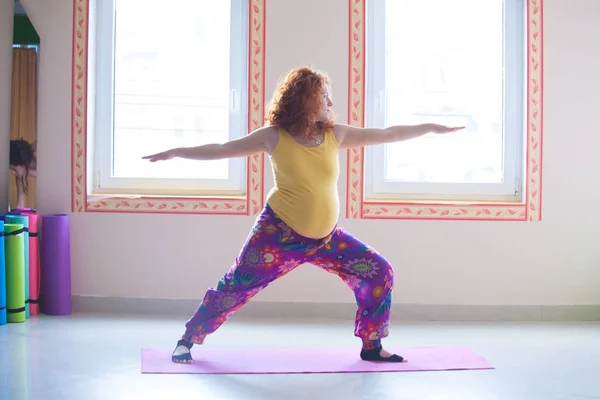 Cabeza roja embarazada joven practicar yoga indoor — Foto de Stock