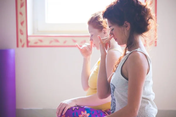 Primer plano de par de mujeres en ejercicios de clase de yoga respiración tec — Foto de Stock