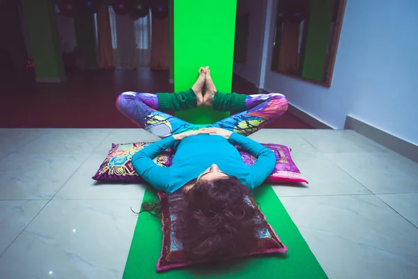 young woman in yoga relaxing pose with legs up the wall
