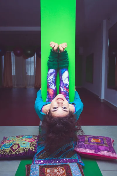 Leende kvinna öva yoga stretching mot kolumn — Stockfoto
