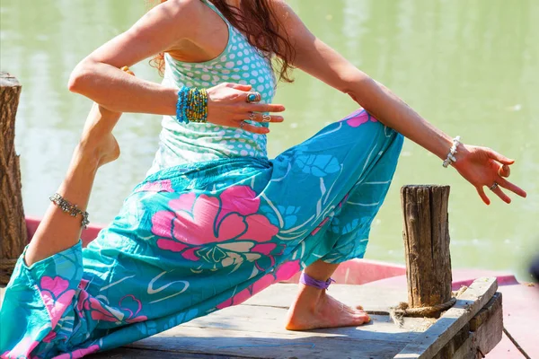 Молодая женщина практикует йогу на открытом воздухе у озера здоровый образ жизни — стоковое фото