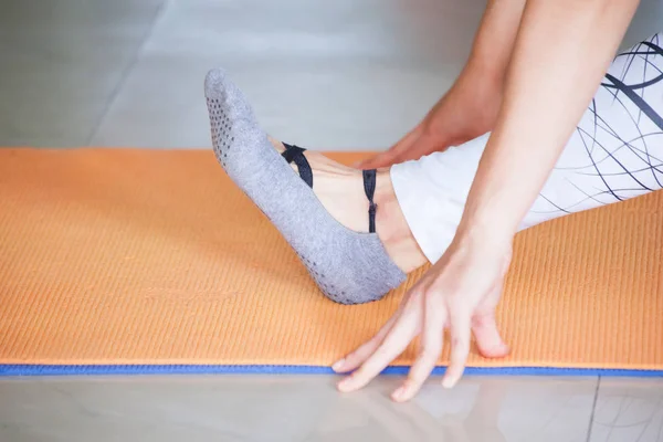 woman hands and feet practice yoga indoor on mat