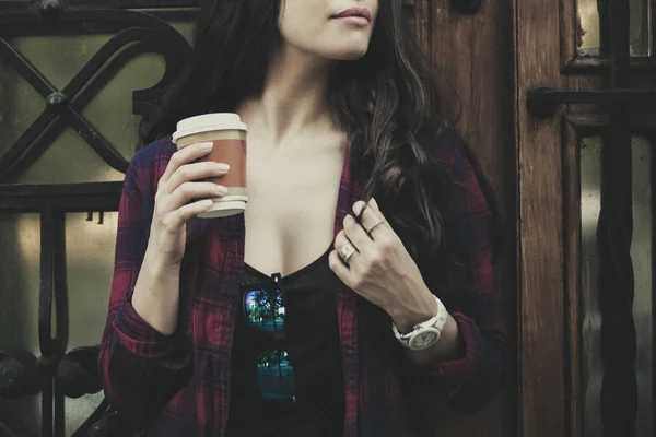 Городская девушка в городе с чашкой кофе перед домом — стоковое фото