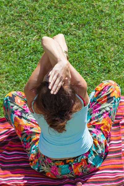 Mulher adulta praticar ioga no quintal na grama sentada postura de águia — Fotografia de Stock