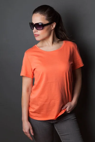 young attractive woman in orange  t-shirt  and sunglasses studio shot gray background,  t shirt mock up