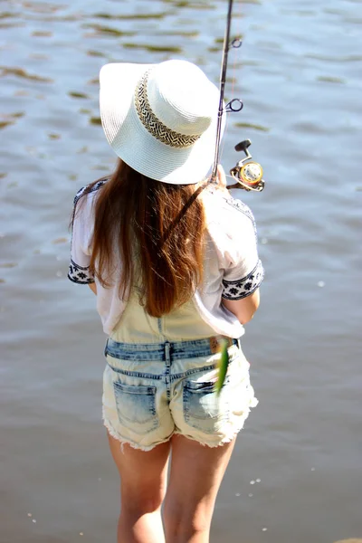 Junge Frau mit Sommersprossen und Latzhose beim Angeln — Stockfoto