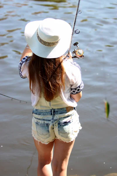 Mujer joven con brotes de verano y dungarees mientras pesca —  Fotos de Stock