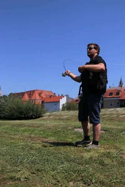 Jovem com vara de pesca pescando em um rio — Fotografia de Stock