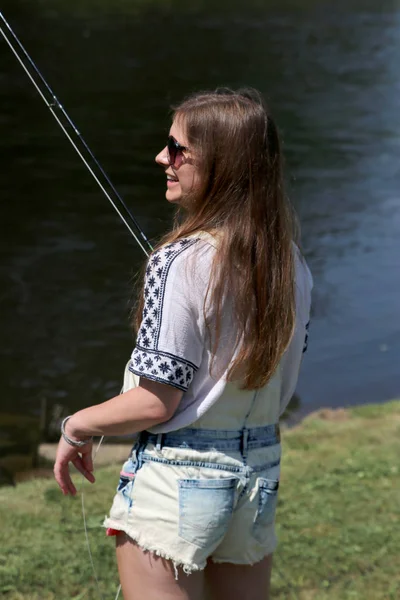 Νεαρή γυναίκα με το καλοκαίρι τα λάχανα και σαλοπέτα ψαρεύοντας — Φωτογραφία Αρχείου