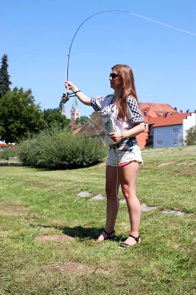 Fiatal nő, nyári hajtások és horgászatot dungarees — Stock Fotó