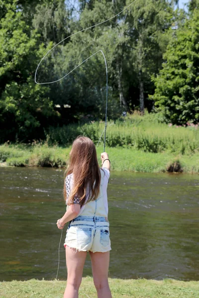 Junge Frau mit Sommersprossen und Latzhose beim Angeln — Stockfoto