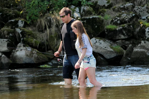 Jonge vrouw met zomer spruiten en werkbroeken tijdens het vissen — Stockfoto