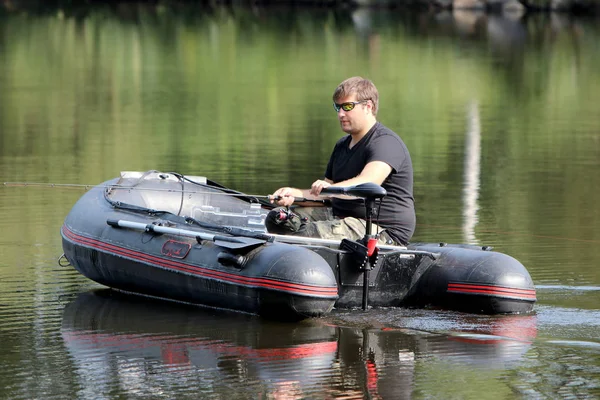 Jongeman in opblaasbare boot — Stockfoto