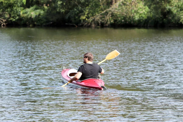 Giovane nel kayak rosso durante la pesca — Foto Stock