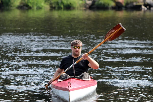 Jeune homme dans le kayak rouge tout en pêchant — Photo