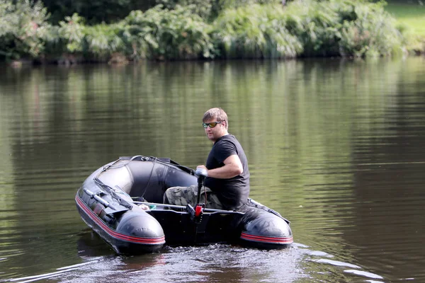 Young man in inflatable boat with electric outboard