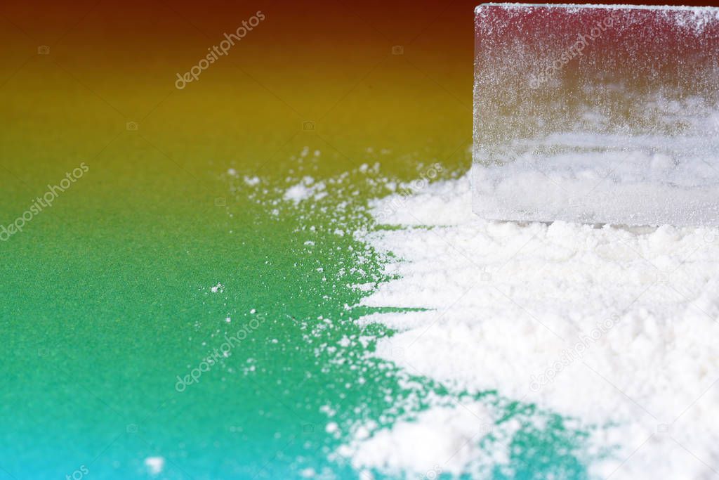 Flour that should look like a white drug with macro lens photographed in front of colorful gradient in the studio