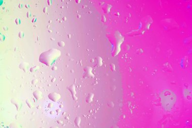 Stüdyoda flaşlar ve renkli filmlerle dolu cam bir çarşafın üzerine su damlaları.