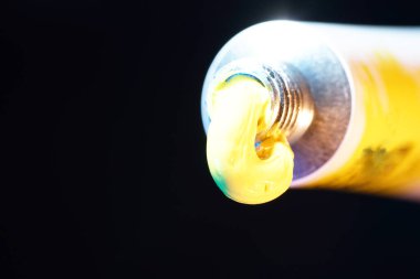 Sarı yeşil boya, siyah arka planda fırçası olan sanatçılar için tüpten yeni çekilmiş.                          